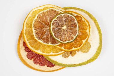 Beyaz arka planda çeşitli turunçgil meyvelerinin kurutulmuş dilimleri