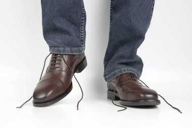 Erkek bacaklarda kot ve beyaz adam üzerinde kahverengi klasik Ayakkabı