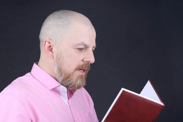 Бородатый Мужчина Розовой Рубашке Читает Книгу — стоковое фото
