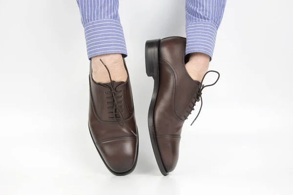 白い背景の上の手に着用古典的な茶色の靴 — ストック写真