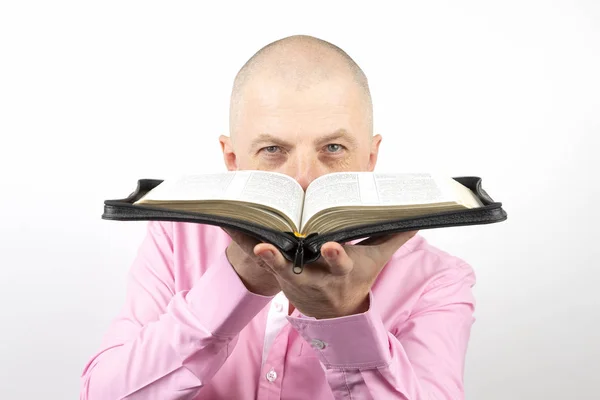Hombre Barbudo Una Camisa Rosa Mira Través Una Biblia Abierta —  Fotos de Stock