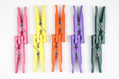 Beyaz bir arka plan üzerinde elbise renkli plastik clothespins dönüştürün