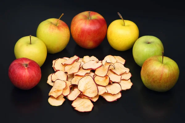 Dried Apple slices and fresh Apple on dark background