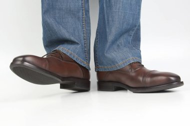 Erkek bacaklarda kot ve beyaz arka plan üzerinde kahverengi klasik Ayakkabı