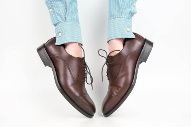 Ellerini üstüne beyaz bir arka plan üzerinde yıpranmış klasik kahverengi Ayakkabı