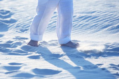 bir çocuğun Beyaz pantolonlu kum üzerinde çıplak ayak