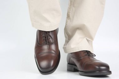 Erkek bacaklarda kot ve beyaz arka plan üzerinde kahverengi klasik Ayakkabı