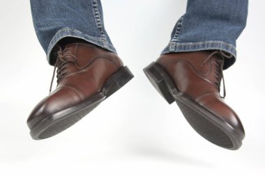 Erkek bacaklarda kot ve beyaz arka plan üzerinde kahverengi klasik Ayakkabı