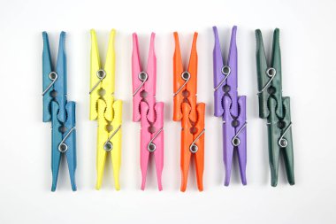 Beyaz bir arka plan üzerinde elbise renkli plastik clothespins dönüştürün