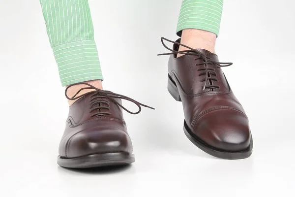 白い背景の上の手に着用古典的な茶色の靴 — ストック写真