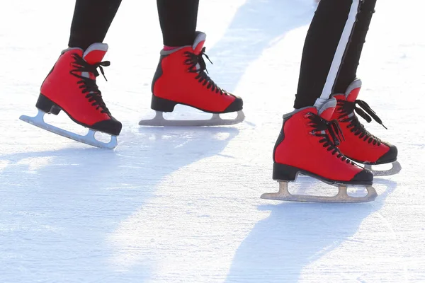 feet in red skates on an ice rink