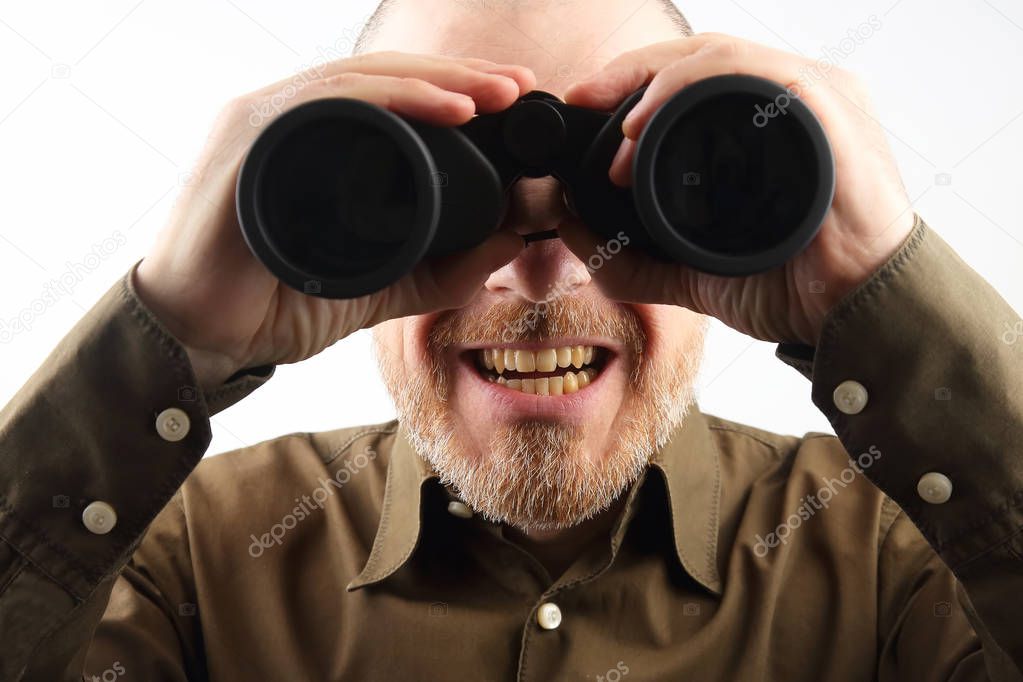 Bearded man looking through binoculars into the distance