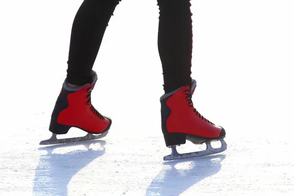 Pés em patins vermelhos em uma pista de gelo — Fotografia de Stock