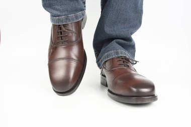 Erkek bacaklarda kot ve beyaz arka plan üzerinde kahverengi klasik Ayakkabı