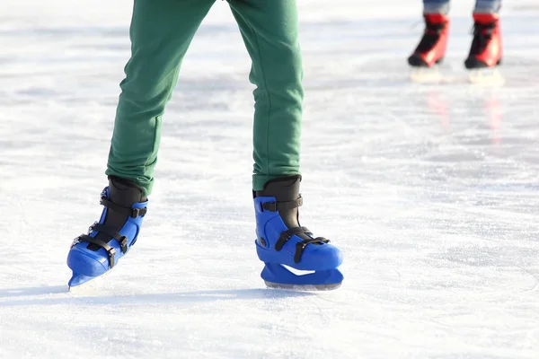 Poten in de blauwe schaatsen op de ijsbaan — Stockfoto