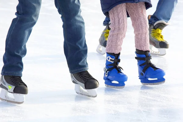 Feet of different people skating on the ice rink — Stock Photo, Image