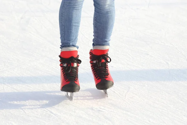Jambes féminines en patins sur une patinoire — Photo