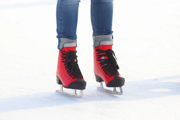 Pés em patins vermelhos em uma pista de gelo — Fotografia de Stock