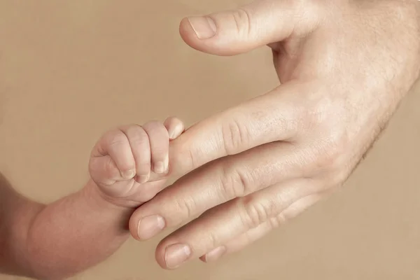 Newborn baby holding his hand on the fingers of parents — Stock Photo, Image