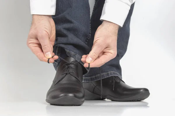 Man tying shoelaces on classic black shoes