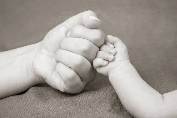 Newborn baby's fist hand and parent's fist together — Stock Photo, Image