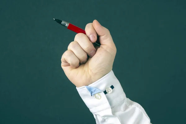 La mano del hombre en una camisa sosteniendo un bolígrafo — Foto de Stock