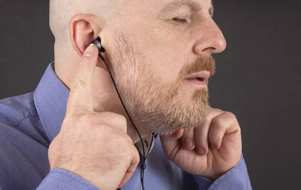 Beard man listening to music through headphones — Stock Photo, Image