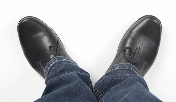 白い背景にジーンズと黒の古典的な靴の男性の足 — ストック写真