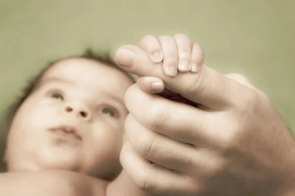 Прекрасный новорожденный ребенок держит руки на пальцах своих родителей — стоковое фото