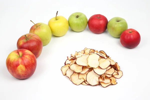 Dried Apple slices surrounded by fresh apples on white backgroun