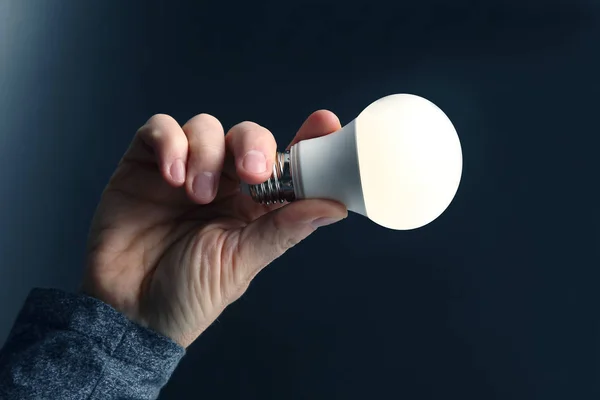 Human hand holding the included led lamp on a dark backgroundInc — Stock Photo, Image