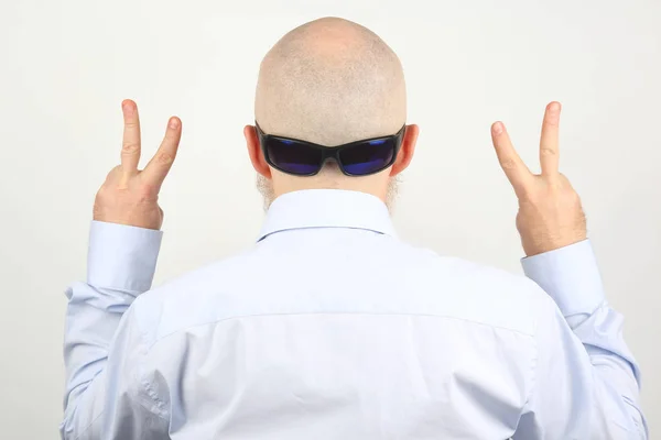 Standing with his back, the man shows signs with his fingers — Stock Photo, Image