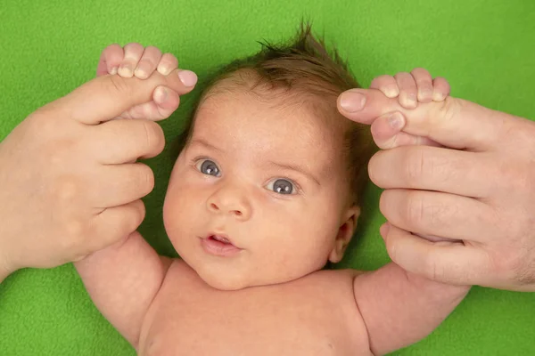 Szczęśliwy noworodek trzymanie rąk swoich rodziców — Zdjęcie stockowe