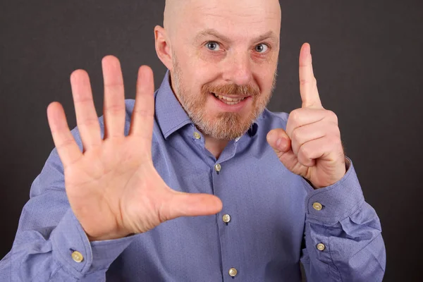 Hombre barbudo muestra una mano hacia arriba y otra señal de stop — Foto de Stock