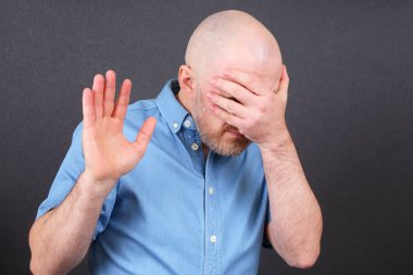 adamın yüzünü eliyle kapsar.