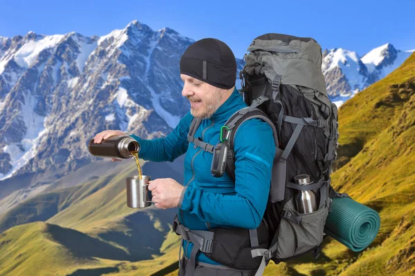 Счастливый человек путешественник наливает чай в кружку на фоне красоты — стоковое фото