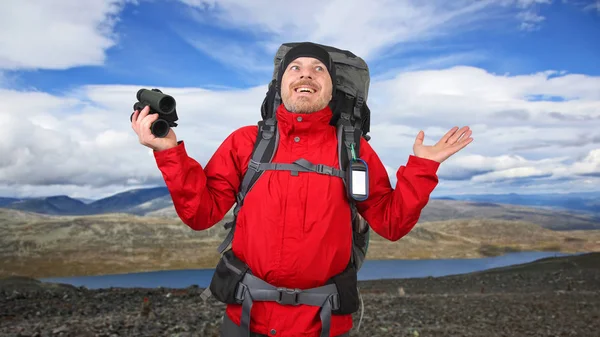 Hombre feliz viajero con prismáticos en la mano en las montañas backgrou —  Fotos de Stock