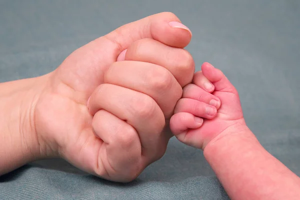 Newborn baby's fist hand and parent's fist together — Stock Photo, Image