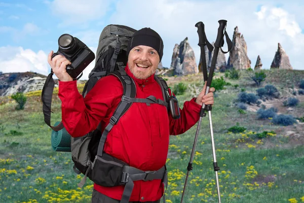 Счастливый бородатый турист с камерой, навигатор и пешеходные палки — стоковое фото