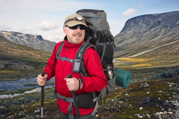 Счастливый человек турист с рюкзаком путешествует в высокогорье — стоковое фото