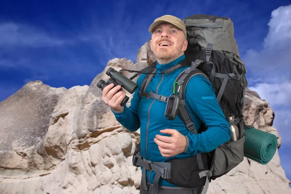 산 백그루에 손에 쌍안경을 가진 행복한 남자 여행자 — 스톡 사진