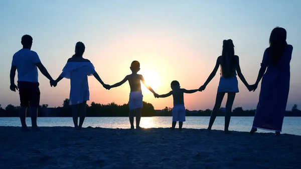 Silhouette de famille sur fond de coucher de soleil — Photo