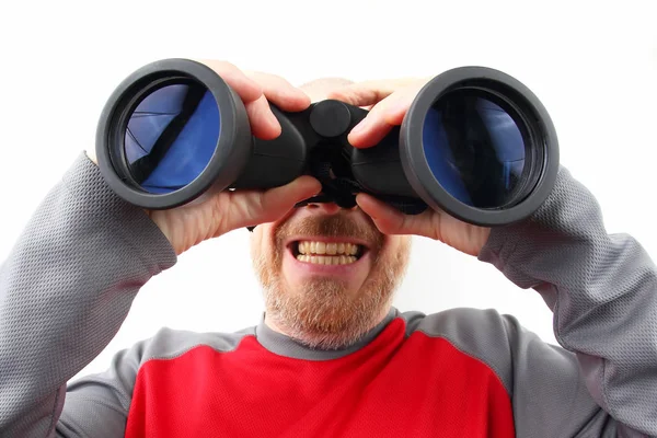 Uomo barbuto guardando attraverso binocoli su sfondo bianco — Foto Stock