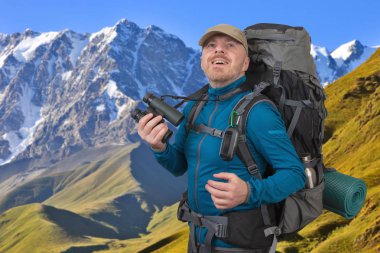 Karla kaplı mounta elinde dürbün ile Mutlu adam gezgin