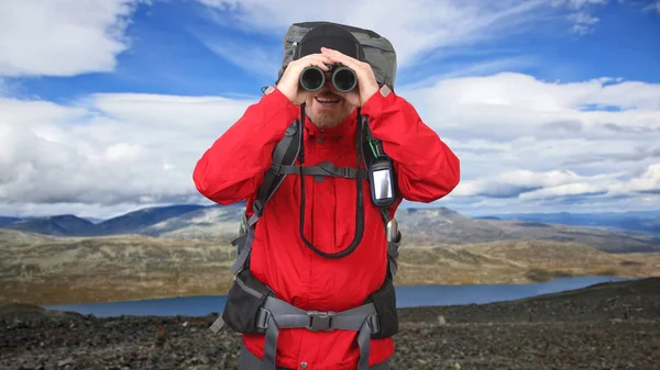 산 백그로에 손에 쌍안경을 가진 행복한 남자 여행자 — 스톡 사진