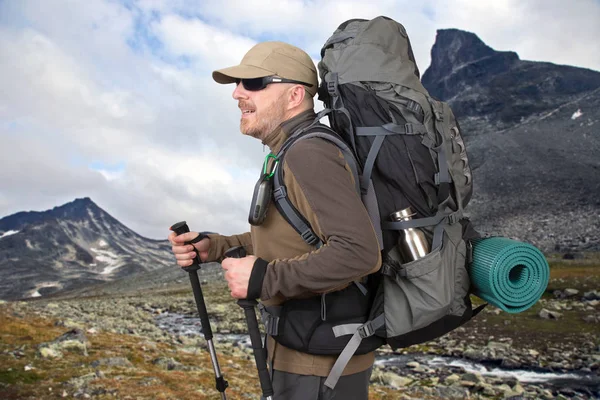 Glücklicher Mann Tourist mit Rucksack ist im Hochland unterwegs — Stockfoto