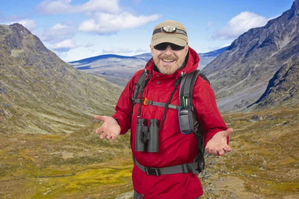 Счастливый человек турист с рюкзаком путешествует в высокогорье — стоковое фото