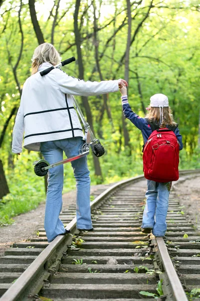 Young girl with a small child walking on railway tracks — Φωτογραφία Αρχείου