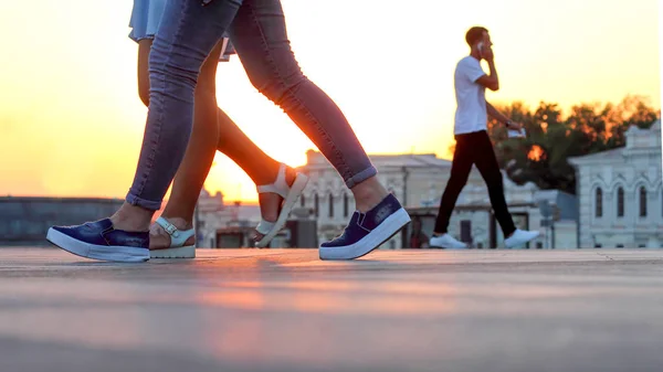 Beine von Menschen, die bei Sonnenuntergang gehen. Freizeit und Erholung . — Stockfoto