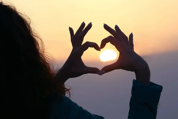 Flickan visar hennes händer tecken på hjärtat mot Setti — Stockfoto